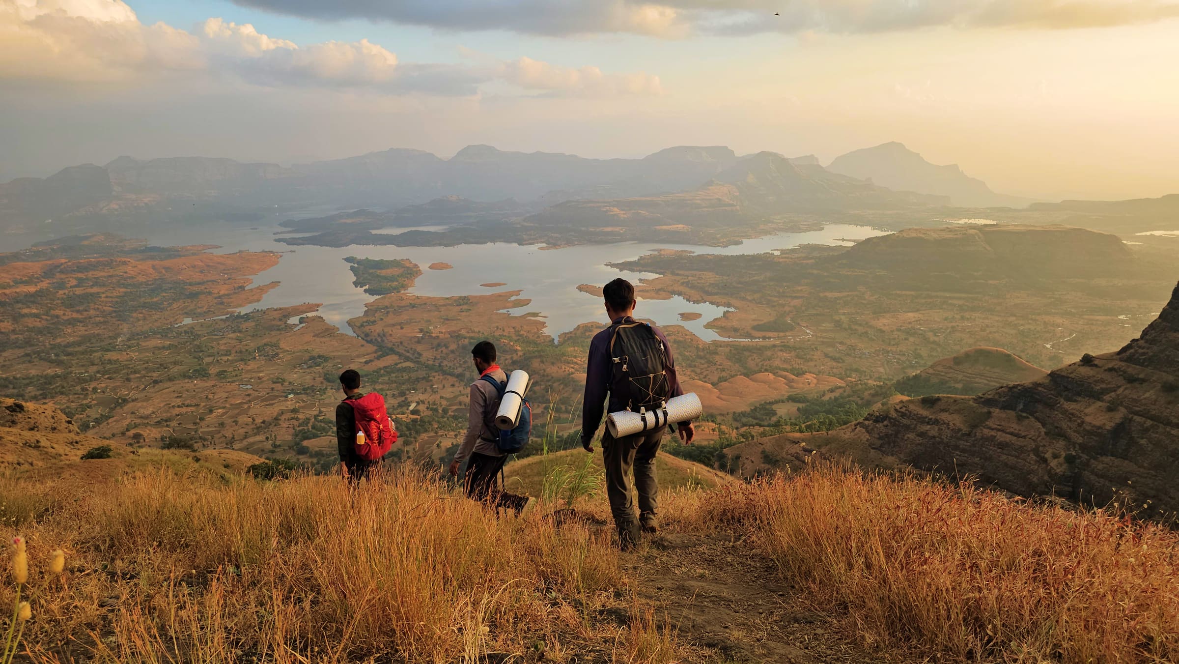 Hikers walking toward a Sahyadri valley at sunset